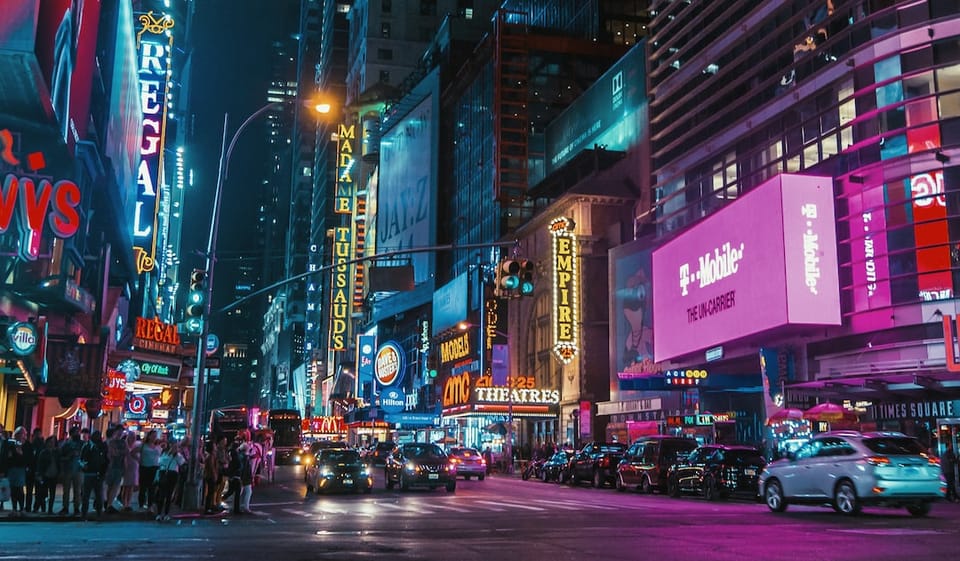 Busy night-time photo of Times Square with advertising prominently displayed everywhere